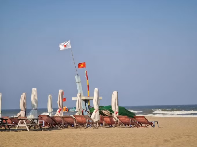 Ghế và ô che nắng nằm phơi mình trên bãi biển...chờ khách. Ảnh: M.Anh