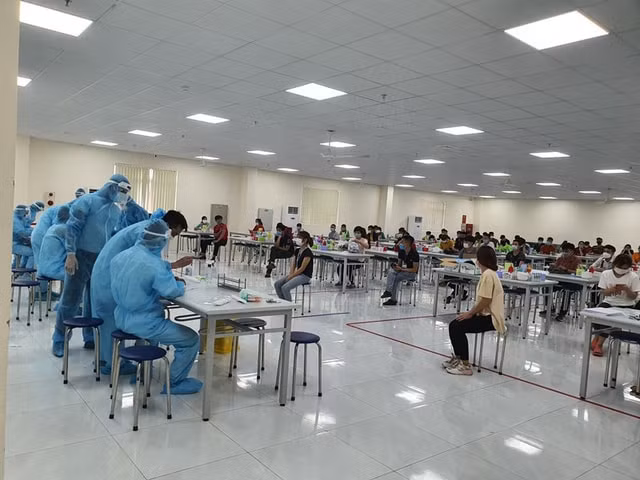 Lực lượng y tế lấy mẫu xét nghiệm COVID-19 cho công nhân ở Bắc Giang.