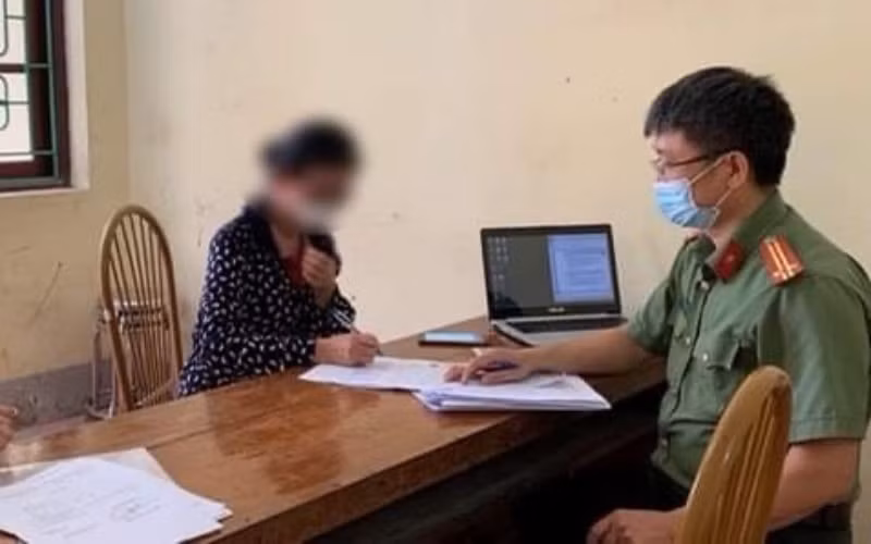 Bà Đ.T.M.A. làm tường trình về hành vi của mình tại cơ quan công an. Ảnh: nhandan.com.vn