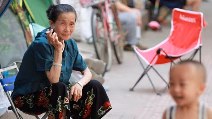 Một phụ nữ lớn tuổi nhìn một cậu bé ở Cáp Nhĩ Tân, tỉnh Hắc Long Giang, đông bắc Trung Quốc: Dongbei có tổng tỷ lệ sinh thấp nhất thế giới với 0,55 ca sinh trên một phụ nữ - Ảnh: Imaginechina / AP