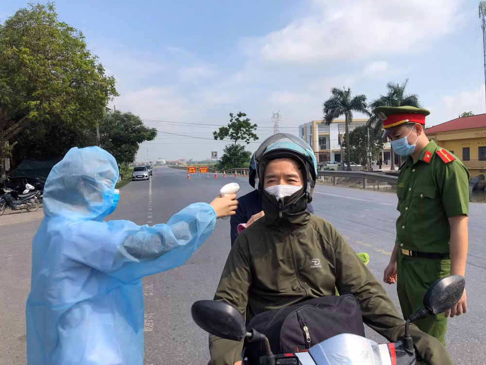 Kiểm tra thân nhiệt người dân tại các điểm chốt kiểm soát dịch bệnh Covid-19 tại huyện Thuận Thành (Bắc Ninh). Ảnh: TL