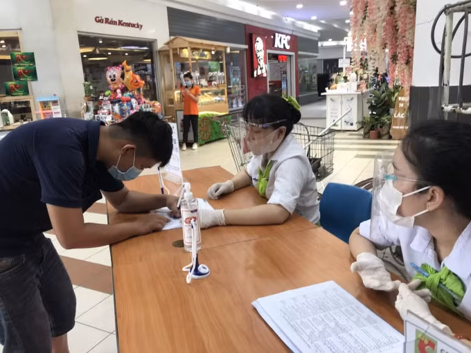 Nhân viên trong siêu thị thực hiện khai báo y tế người dân mua sắm tại siêu thị Big C Đồng Nai sau khi kết thúc phong tỏa.