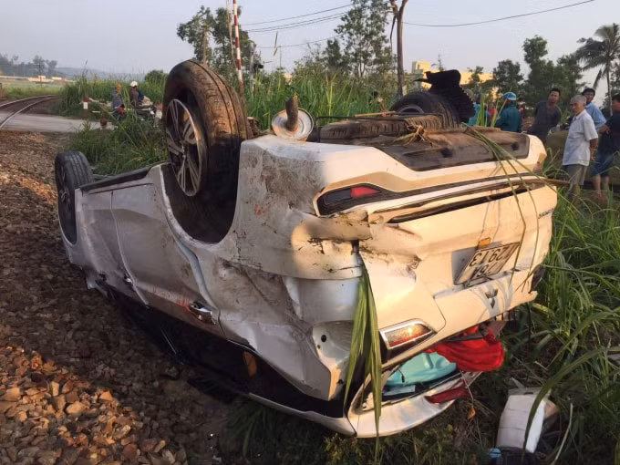 Chiếc xe ô tô bị cán nát, lật ngửa lên trời sau vụ tai nạn.