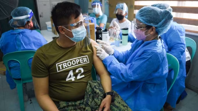 Một sĩ quan cảnh sát tiêm vắc xin CoronaVac đầu tiên của Sinovac Biotech tại Cảng cá Navotas, thuộc thành phố Navotas của Philippines, vào ngày 10 tháng 6 - Ảnh: Reuters
