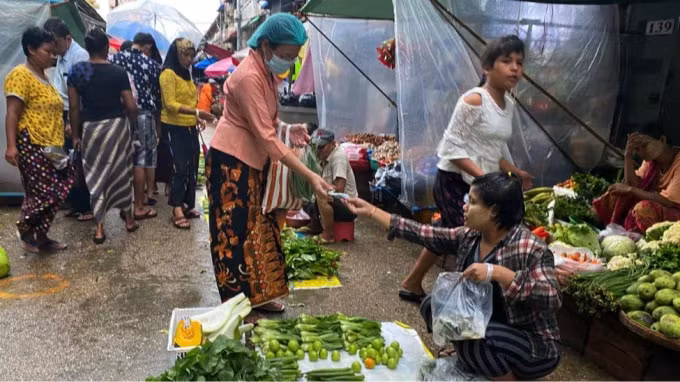Một người tiêu dùng Myanmar mua rau tại chợ địa phương vào ngày 15 tháng 6. Mọi người đang dần trở lại mua sắm và làm việc, nhưng vẫn tiếp tục lo ngại về tình trạng thiếu tiền mặt. Ảnh: Nikkei.