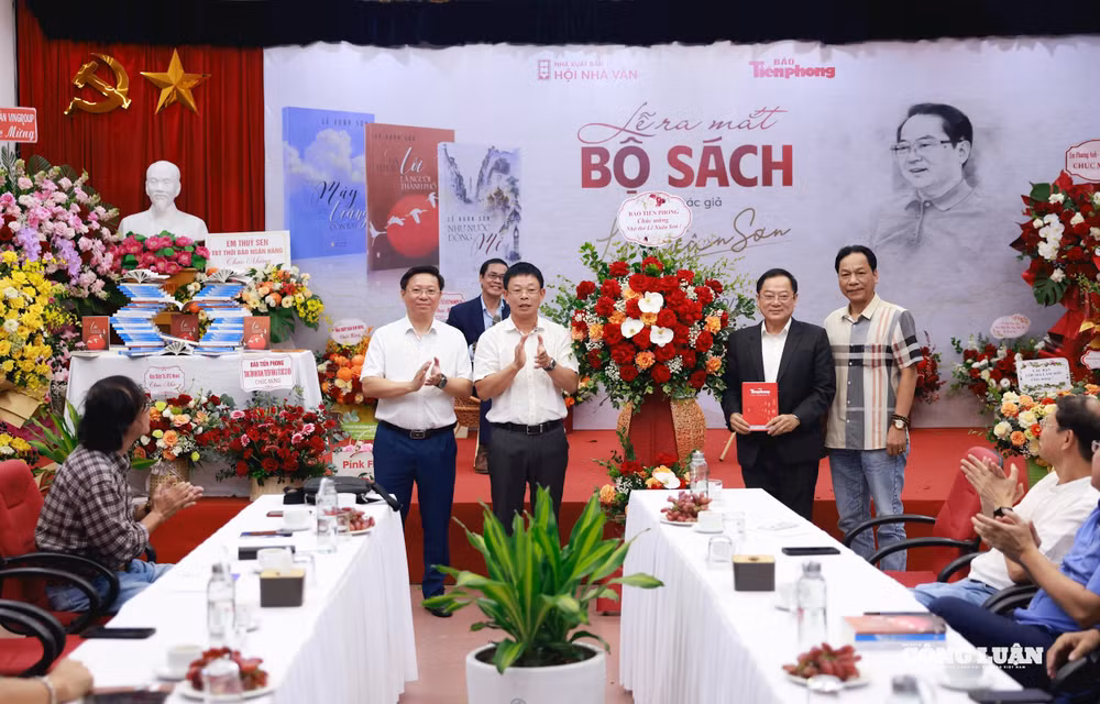 Nhà báo, nhà thơ Lê Xuân Sơn đón nhận món quà và lẵng hoa của Tổng Biên tập báo Tiền Phong Phùng Công Sưởng.
