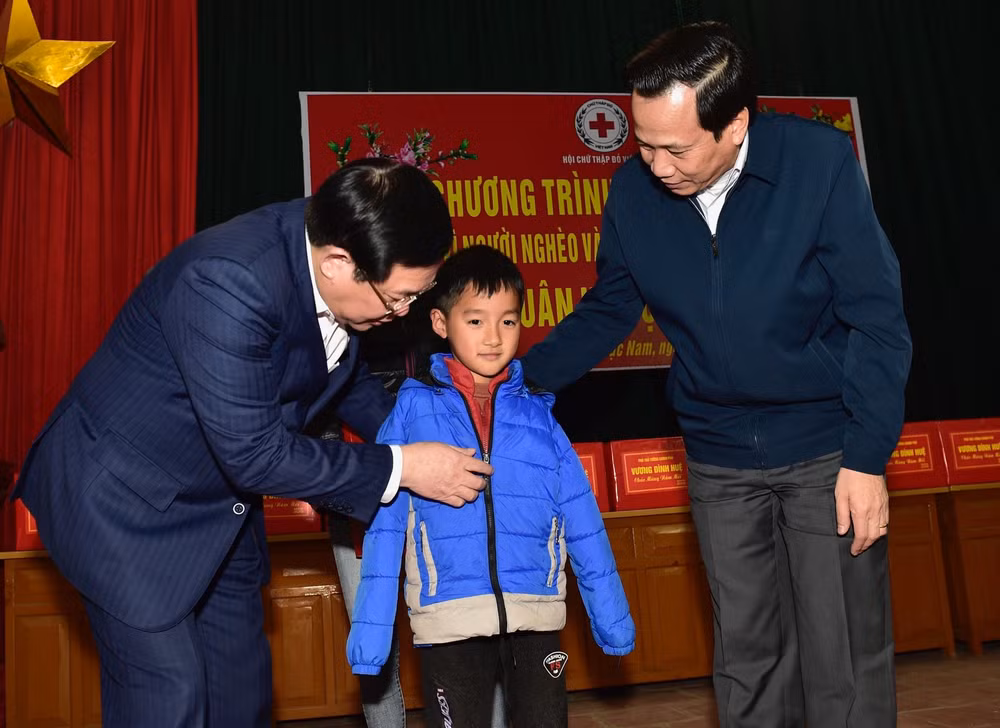 Phó Thủ tướng Vương Đình Huệ tặng quà cho các cháu nhỏ thuộc hộ nghèo, chính sách tại xã Lan Mẫu. Ảnh: VGP