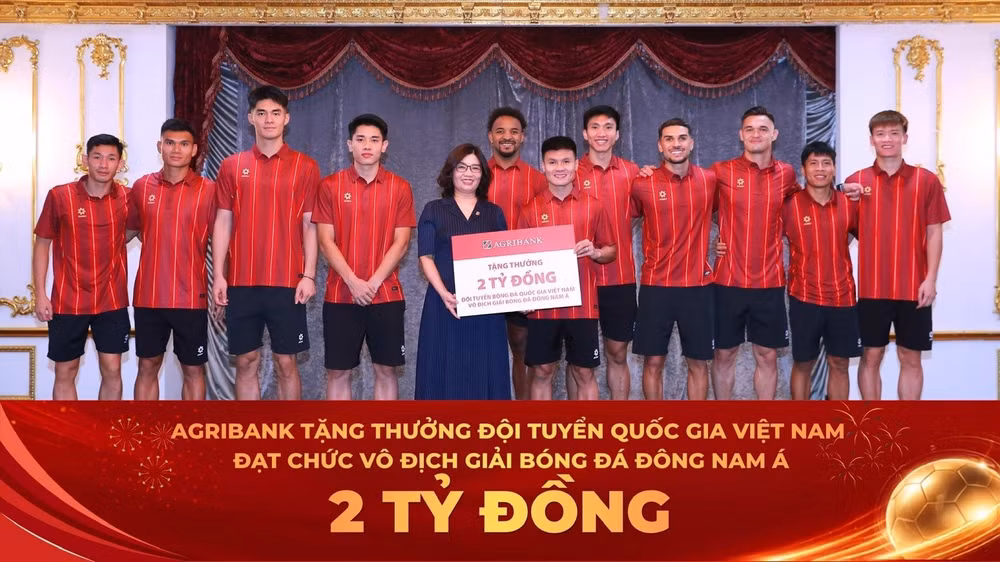 Đại diện Agribank, bà Từ Thị Kim Thanh - Thành viên HĐTV trao thưởng 2 tỷ đồng chúc mừng thành tích xuất sắc của Đội tuyển Quốc gia Việt Nam