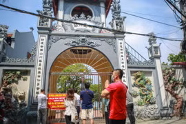 Hà Nội: Đền chùa đóng cửa, người dân hành lễ, thắp hương, vái vọng trước cổng chùa