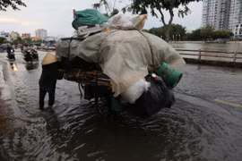 Triều cường ở TP. HCM dâng cao, đường ngập sâu khiến người dân té ngã sõng soài
