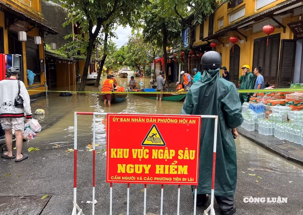 Lực lượng chức năng cắm biển cảnh báo người dân không di chuyển qua các điểm ngập sâu.