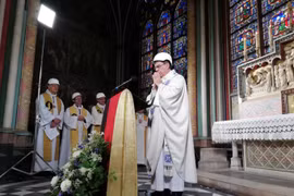 Các cha xứ đội mũ bảo hiểm cầu nguyện tại Notre Dame Paris