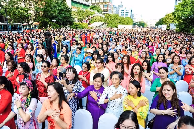 Chị em phụ nữ tham gia đồng diễn với áo dài trong sáng 3/3. Ảnh: Baotintuc