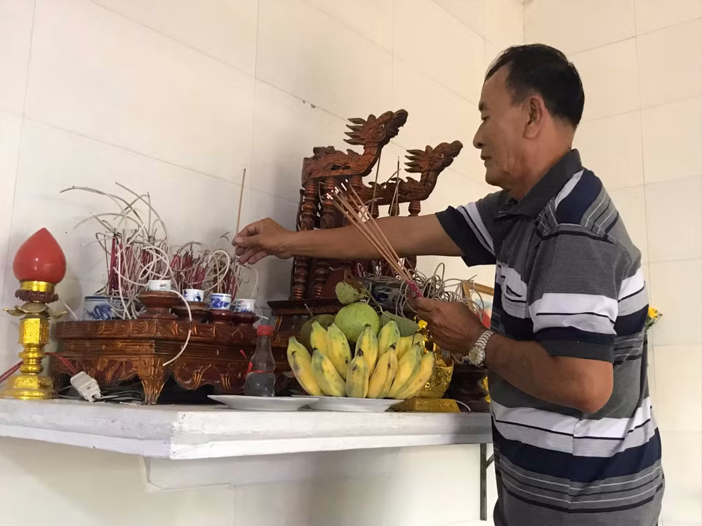 Ông Dương thắp hương trên bàn thờ gia tiên và thờ chính ông. Ảnh PV