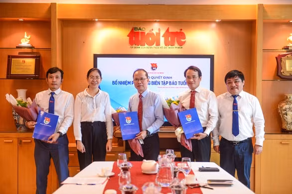 Bí thư Thành đoàn TP.HCM Phan Thị Thanh Phương và Tổng Biên tập báo Tuổi Trẻ Lê Thế Chữ (bìa phải) tặng hoa chúc mừng ba Phó Tổng Biên tập báo Tuổi Trẻ - Ảnh: Quang Định