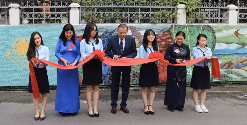 Các đại biểu thực hiện nghi thức cắt băng khánh thành bức tranh tường. Ảnh: TĐ
