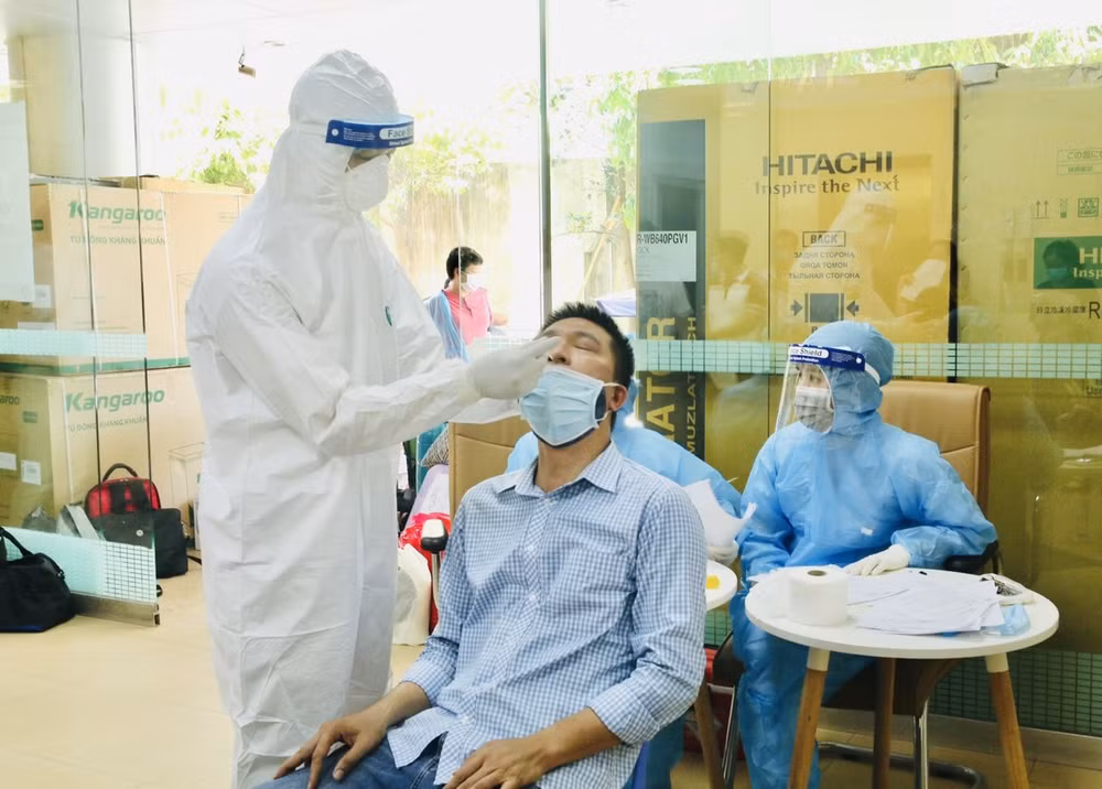 Nhân viên y tế lấy mẫu xét nghiệm cho các trường hợp liên quan bệnh nhân Covid-19 làm việc tại Viện Cơ khí Năng lượng và Mỏ VINACOMIN. Ảnh: kinhtedothi.vn