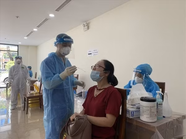 Cơ quan y tế thực hiện xét nghiệm với các phóng viên tham dự đưa tin Kỳ họp 1, Quốc hội khoá XV. Ảnh: LĐO