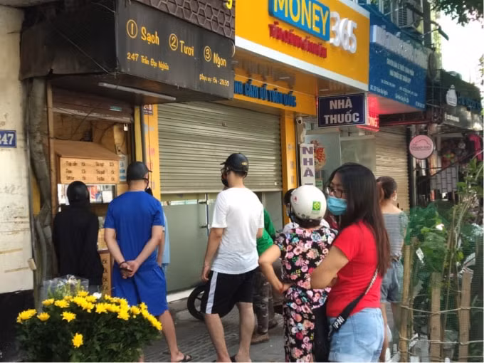 Tại một quán bánh mì trên đường Trần Đại Nghĩa, người dân xếp hàng không đảm bảo khoảng cách an toàn.