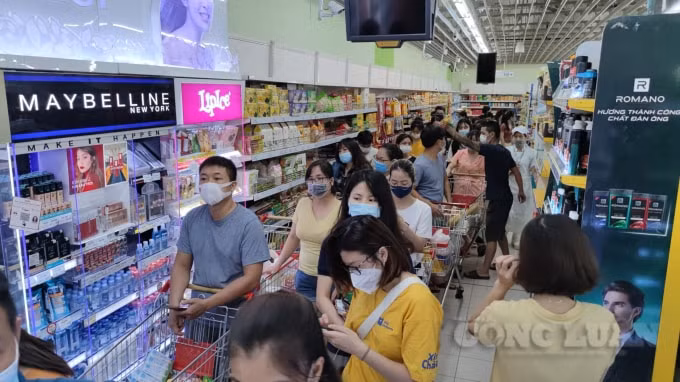 Lượng người dân khá đông đổ vào siêu thị BIC Lê Trọng Tấn để mua, tích trữ lương thực trong tối ngày 18/7.