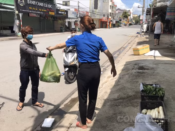 Công nhân đến nhận rau xanh tại điểm phân phát do các chủ nhà trọ và đoàn viên phối hợp thực hiện.