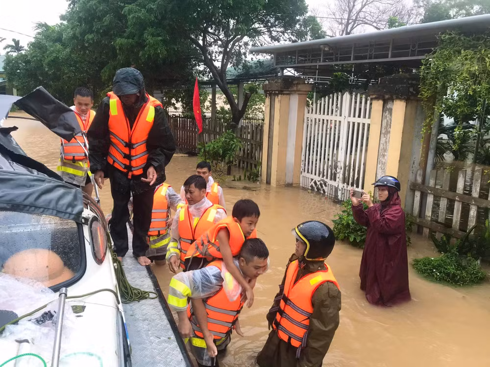 Phóng viên Đăng Đức (áo mưa tím) báo Dân Trí thường trú Quảng Trị, anh đang ghi lại cảnh cứu trợ và sơ tán của các lực lượng quân đội, công an.