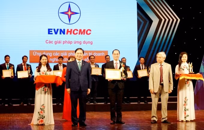Ông Lê Chí Dũng (đứng giữa) thay mặt EVNHCMC đón bằng chứng nhận và giải thưởng 