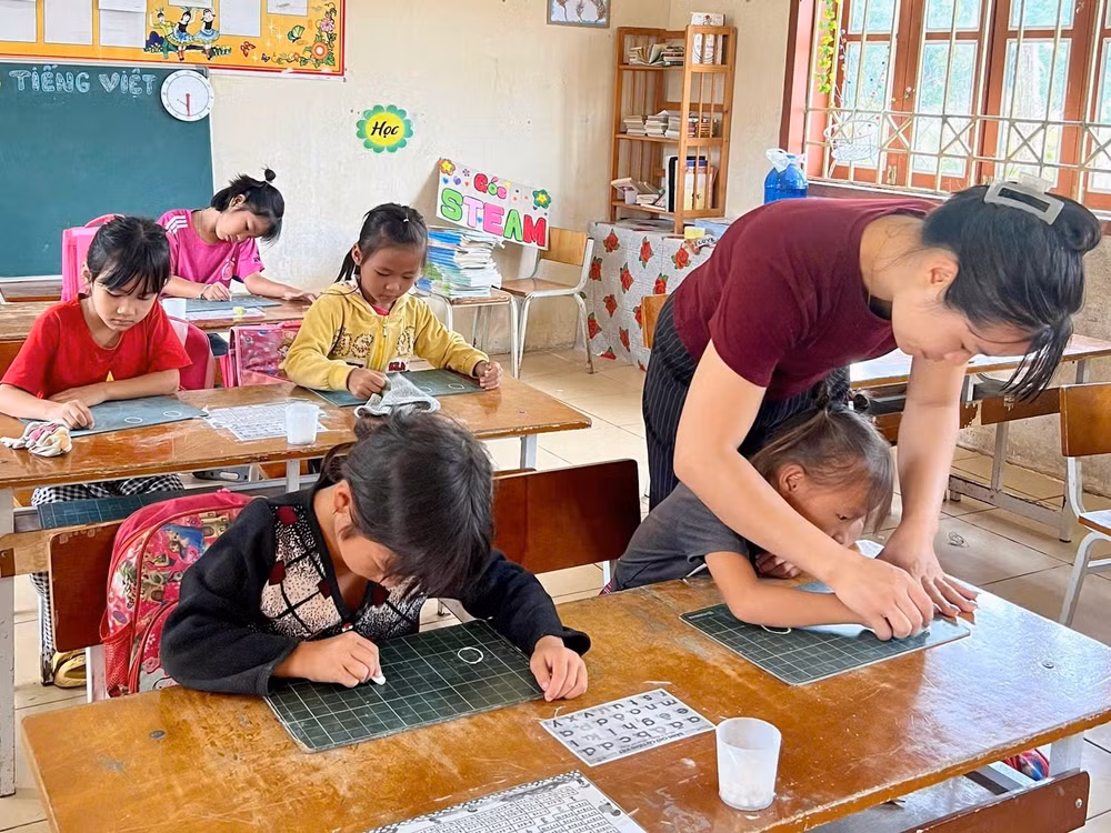 Tại Sơn La, cô kiên nhẫn cầm tay, nắn nót từng nét chữ đầu đời cho học sinh lớp 1.