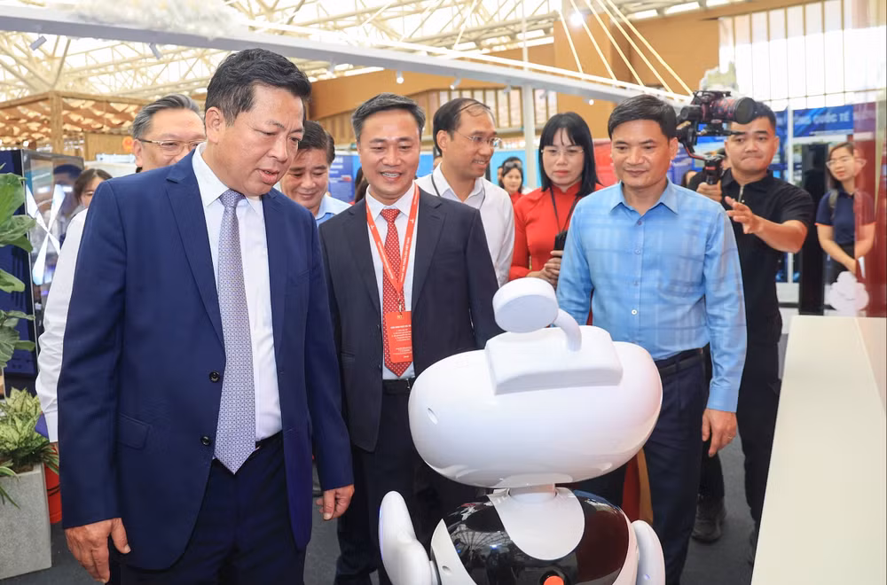 Bộ trưởng Trần Hồng Minh và Thứ trưởng Nguyễn Việt Hùng nghe giới thiệu về robot lễ tân E1 với khả năng cung cấp thông tin nhanh chóng - chi tiết - chính xác tại gian trưng bày của Bộ Xây dựng.