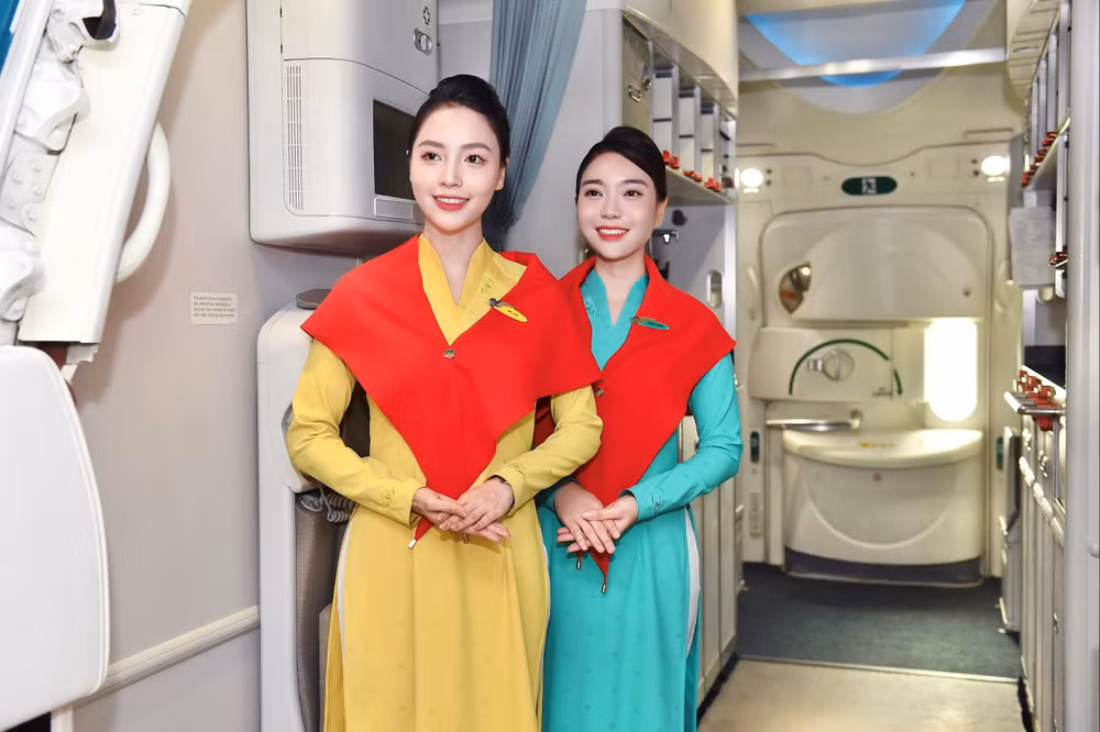 2. Tiếp viên Vietnam Airlines quàng khăn đỏ sao vàng, nở nụ cười chào đón hành khách trong không khí lễ hội