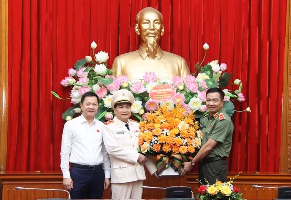 Thiếu tướng Nguyễn Sĩ Quang (đứng giữa) đón nhận lẵng hoa chúc mừng. Ảnh: LĐ
