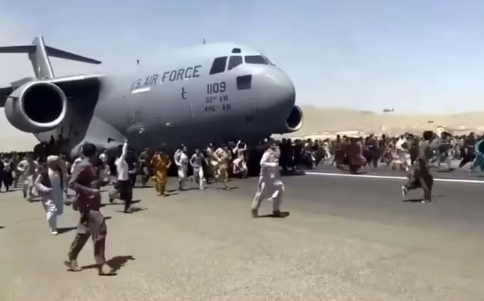 Hình ảnh hỗn loạn tại sân bay Kabul khi hàng trăm người cố gắng đu bám lên một máy bay quân sự Mỹ, với hy vọng rời khỏi Afghanistan - Ảnh: Cắt từ video