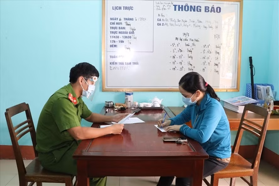 Công an lập biên bản xử lý đối với bà Trần Thị Thủy vì sửa giấy xét nghiệm đã hết hiệu lực để qua chốt kiểm dịch. Ảnh: TTXVN
