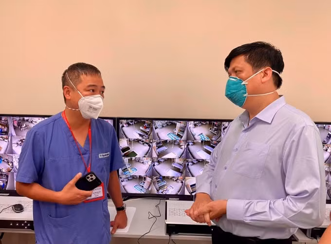 Bộ trưởng Nguyễn Thanh Long (phải) trò chuyện với ông Nguyễn Lân Hiếu, Giám đốc Bệnh viện Đại học Y Hà Nội đang thực hiện hỗ trợ điều trị cấp cứu bệnh nhân COVID-19 tại Bình Dương (ảnh TL).