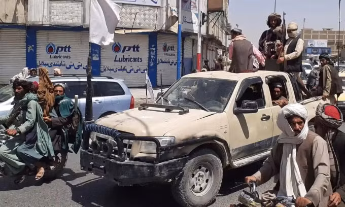 Các chiến binh Taliban lái một chiếc xe của quân đội quốc gia Afghanistan qua một con phố ở Kandahar hôm thứ Sáu. Ảnh: AFP / Getty Images