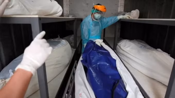 Các nhân viên chăm sóc sức khỏe chuyển một thi thể vào nhà xác bệnh viện ở Pathum Thani, Thái Lan, vào ngày 31 tháng 7. © Reuters