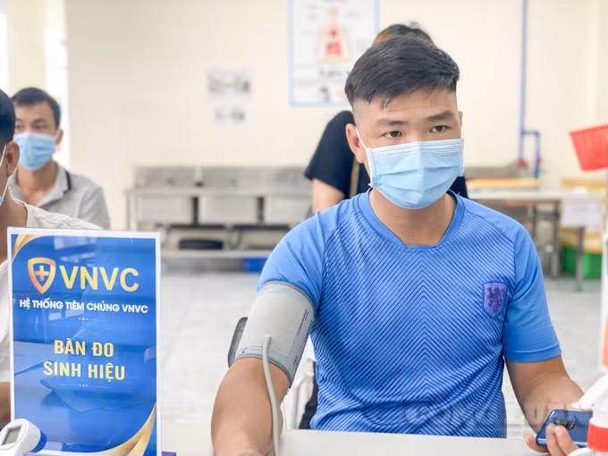 Người dân được kiểm tra sức khoẻ trước khi tiêm
