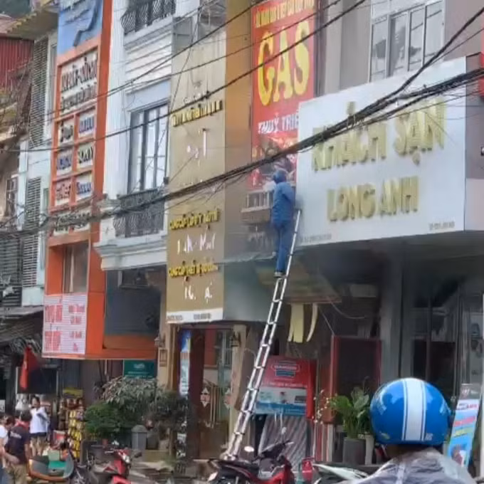 Anh Mai Đức Cảnh nhanh chóng dùng thang của VNPT lên ban công tầng 2 cứu người.