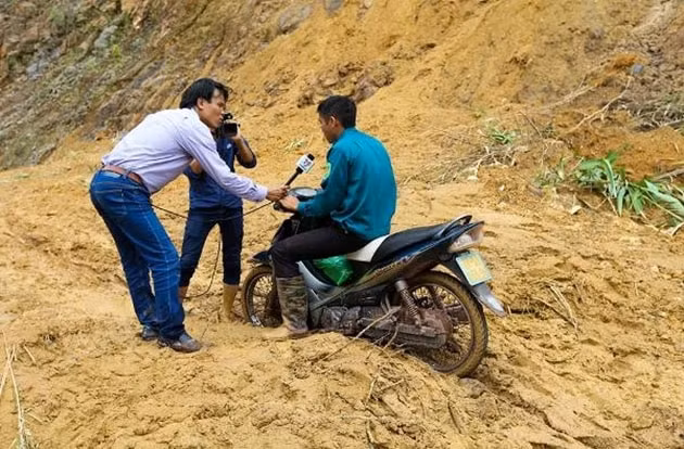 Nhà báo Phan Tuấn Anh tranh thủ phỏng vấn người dân về thiệt hại sau sạt lở. Ảnh: NVCC