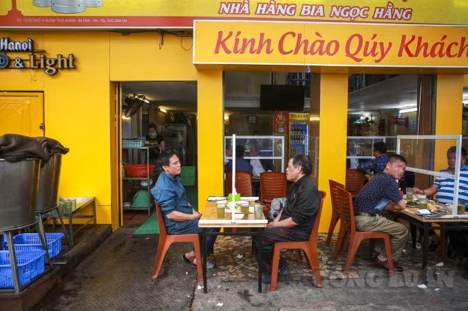 Nhiều cửa hàng đã cho lắp các tấm kính chắn giọt theo đúng chỉ thị của Ban chỉ đạo chống dịch thành phố Hà Nội, người dân ngồi giãn cách nhau.