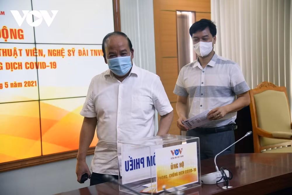 Các Phó Tổng Giám đốc VOV - ông Trần Minh Hùng và ông Ngô Minh Hiển ủng hộ phòng chống dịch. Ảnh: VOV