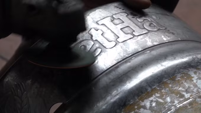 Chủ cơ sở này đang cho thực hiện việc cắt tai, mài vỏ những bom bia mang thương hiệu nổi tiếng khác. Ảnh Hà Long.