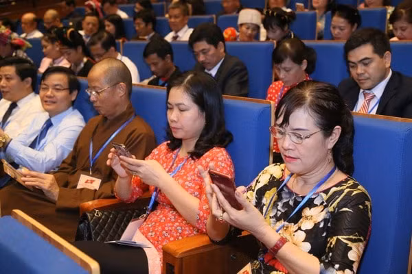 Các đại biểu nhắn tin ủng hộ người nghèo. Ảnh: ĐĐK