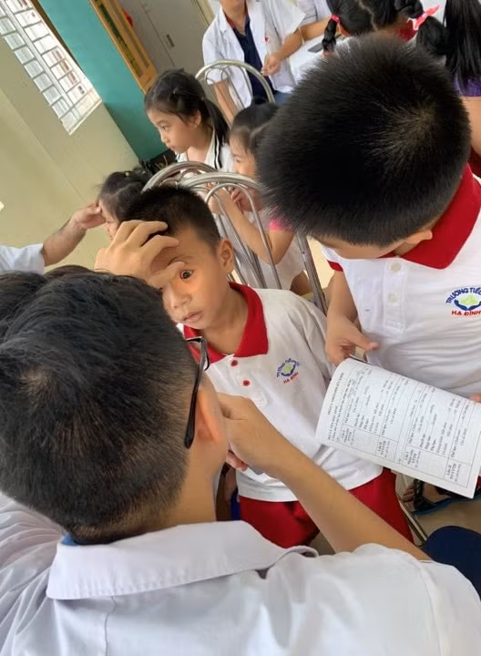 Sáng nay 13/9, các bác sĩ đang tiến hành khám sức khỏe cho học sinh trường tiểu học Hạ Đình, khu vực bán kính cách 500 trong vụ cháy Công ty bóng đèn, phích Rạng Đông. Ảnh: tienphong