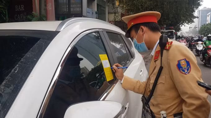 Cảnh sát giao thông Hà Nội dán thông báo phạt nguội đối với phương tiện dừng, đỗ trái phép. Ảnh: TL