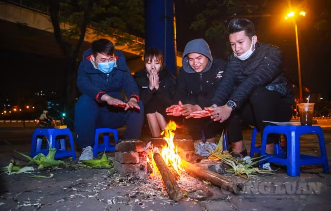 Nhóm bạn trẻ quây quần vui vẻ bên đống lửa nhỏ. Bạn Hùng cho hay, bình thường tôi vẫn cùng bạn bè tụ tập ngồi quán nước vỉa hè vào mỗi tối, hôm nay nhiệt độ xuống quá thấp, cũng may có đống lửa nhỏ bên cạnh để sửa ấm.