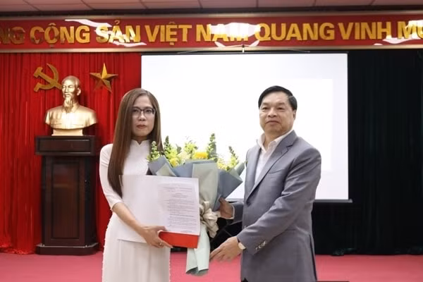 Ông Lê Mạnh Hùng chúc mừng và trao quyết định cho bà Vũ Diệu Thu. Ảnh: dangcongsan.vn