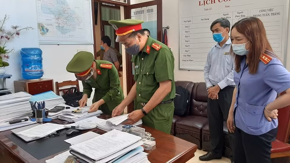 Lực lượng chức năng thực hiện khám xét nơi làm việc của một bị can. Ảnh: laodong.vn