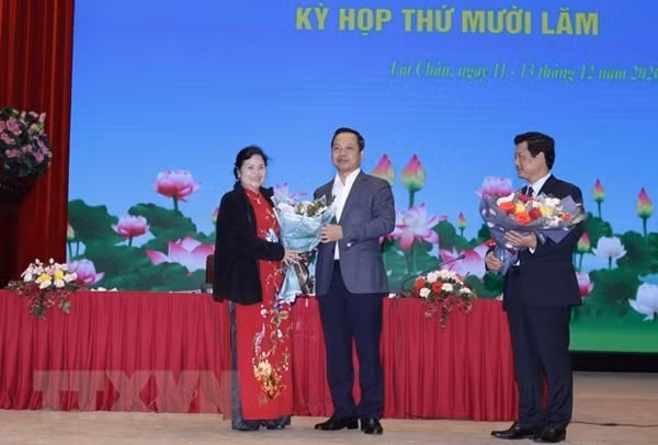 Chủ tịch UBND tỉnh Lai Châu Trần Tiến Dũng tặng hoa chúc mừng bà Giàng Páo Mỷ. Ảnh: TTXVN