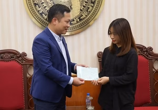 Quyền Tổng Giám đốc Cổng TTĐT Chính phủ Nguyễn Hồng Sâm thăm hỏi, động viên và trao tặng sổ tiết kiệm cho con gái cả của nhà báo - liệt sĩ Phạm Văn Hướng. Ảnh: VGP